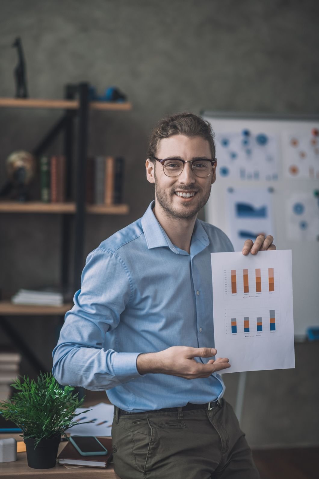 young bearded man in blue shirt showing a draft sasztjh.jpg